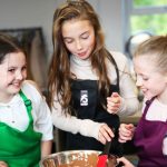 image of three girls cooking at school camp in Didsbury