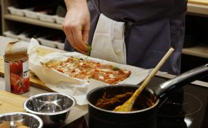Image of Muscle Gain Fit Food Class participant adding toppings to Cauliflower Pizza at Food Sorcery, Didsbury